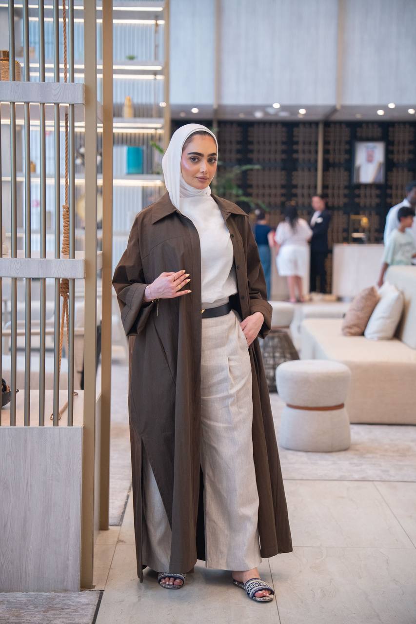 طقم بليزر باللون البني مع قميص و بنطلون كحلي .