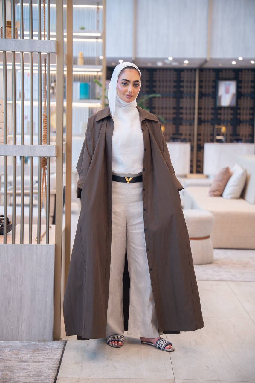 طقم بليزر باللون البني مع قميص و بنطلون كحلي .