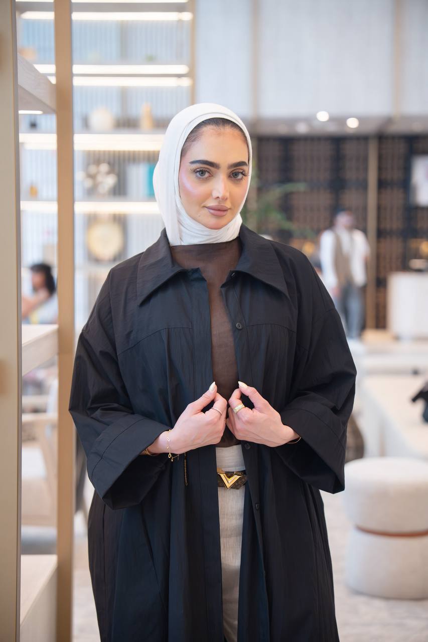 طقم ترنش كوت اسود مع بلوزة حفر و بنطلون بيج .