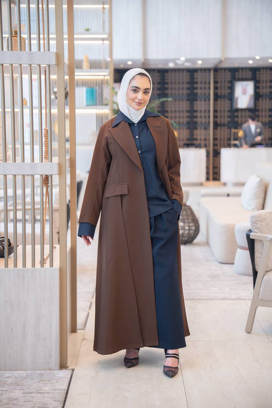 طقم بليزر باللون البني مع قميص و بنطلون كحلي .